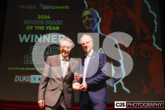 Peter Duke (Duke Travel) presenting John Watterson with the Duke Travel Coach of the Year award. John collecting on behalf of Elliot Baxter (Cycling). Isle of Man Sports Awards 2024. Photo by Callum Staley (CJS Photography)