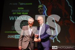 Peter Duke (Duke Travel) presenting John Watterson with the Duke Travel Coach of the Year award. John collecting on behalf of Elliot Baxter (Cycling). Isle of Man Sports Awards 2024. Photo by Callum Staley (CJS Photography)