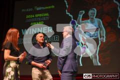Nikki Arthur and Orran Smith recipients of the Special Achievement Award with host James Davis.  Isle of Man Sports Awards 2024. Photo by Callum Staley (CJS Photography)